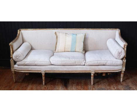 A George III White Painted & Parcel-Gilt Sofa, Late 18th Century with a Reeded & Chanelled Toprail.The Arms have Scrolled Ter