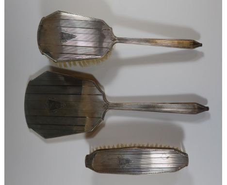 A George VI Silver Backed Three Part Hand Mirror and Brush Set with engine turned decoration and initialled B, Birmingham 194