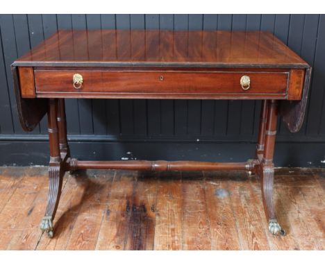 An Early C19th Regency Mahogany and Tulipwood Crossbanded Sofa Table with a frieze drawer, on brass claw caps and castors, 29