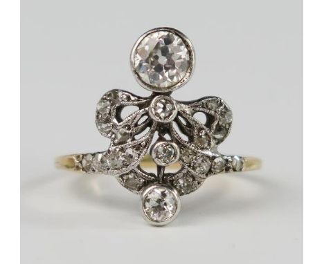 An Unusual Unmarked Gold and Diamond Ring in a millegrain and rub over setting, size P.5, 3.9g. The primary bright cut diamon
