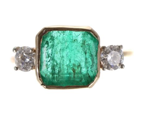 Impressive 18ct emerald and diamond three stone ring, the rub-over set emerald 2.80ct approx, with two round brilliant-cut di