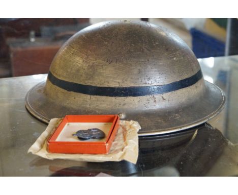A Vintage air raid wardens helmet together with original booklet and badge.