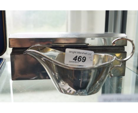 A Sheffield hallmarked silver sauce boat together with an engine turned hallmarked silver rectangular Art Deco style cigarett