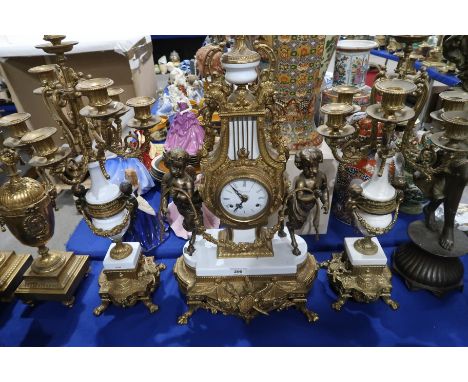 An Italian Imperial clock garniture the dial with Roman numerals, standing on gilt metal and white enamel base with Puti to e