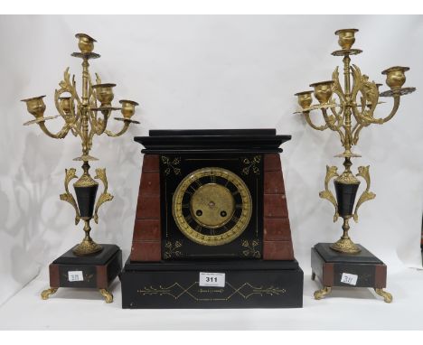 A French red marble and black slate mantle clock with a pair of candelabra garnitures, 43cm high Condition Report: Available 