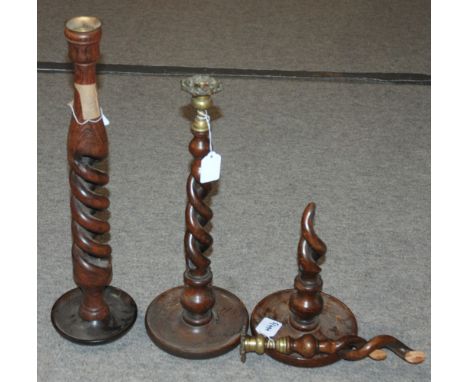 An oak barley twist candle stick, 53m high and another pair of candlesticks, one damaged (3) Condition Report: Available upon