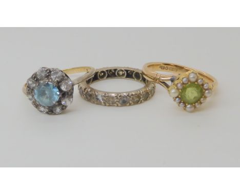 A 9ct gold peridot and pearl set ring size K1/2, a yellow metal clear gem set eternity ring size J1/2 and a silver and gold b