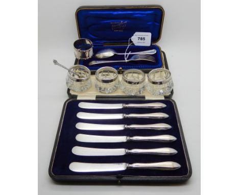 A lot comprising a cased two piece silver christening set, four silver mounted glass salts, a cased set of silver handles kni