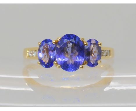 An 18ct gold tanzanite and diamond ring, central tanzanite approx 7.9mm x 6.1mm, diamond content estimated approx 0.10cts, fi