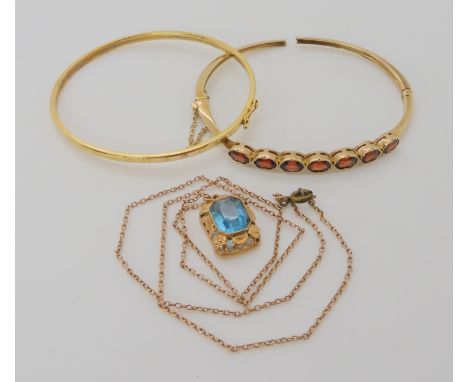 A 9ct gold bangle with hearts motif, a further bangle set with garnets (af), a yellow metal pendant set with a blue glass gem