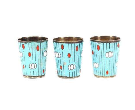 Three Russian white metal and enamel Vodka shot beakers, with gilded interiors, marks to base