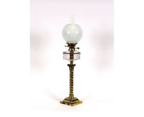 A Victorian brass column oil lamp, having clear glass reservoir and opaque shade, 80cm high
