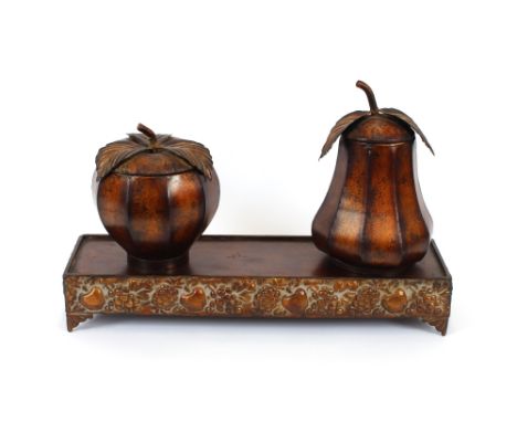 A Toleware gilded tea caddy, in the form of a pear; another in the form of an apple, both raised on a carved stand