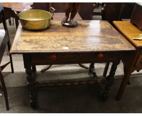 A 17th Century and later oak side table, the overhanging top above single drawer, raised on baluster turned and block support