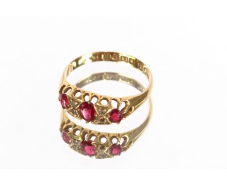 An 18 carat gold three stone ruby and diamond ring