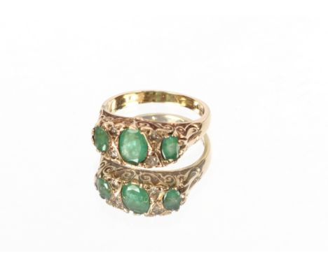 A 9 carat gold three stone emerald and diamond ring