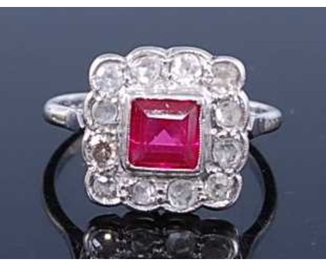 A white metal, ruby and diamond square cluster ring, comprising a square cut ruby surrounded by twelve Old European single ro