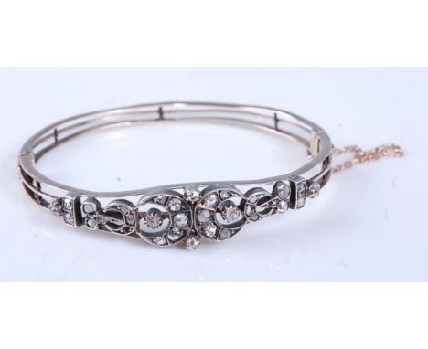 A 19th century yellow and white metal diamond hinged bangle, featuring 32 rose cut diamonds in grain settings, in openwork cr
