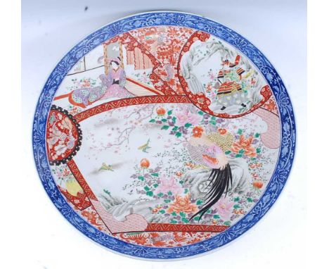 A Japanese Meiji period charger, enamel decorated with figure and exotic bird reserves in the Imari palette, all within a blu