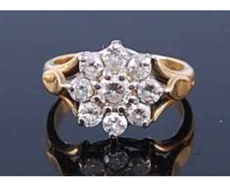 A yellow metal diamond flower head cluster ring, the centre round cut weighing approx 0.2 carats, in a surround of eight smal