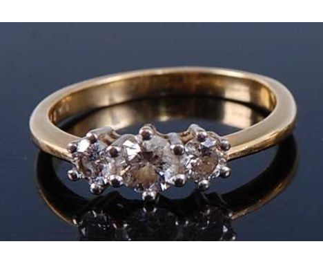 An 18ct gold diamond 'trilogy' ring, the claw set brilliants in a line setting, total diamond weight stated as 0.75 carats, c