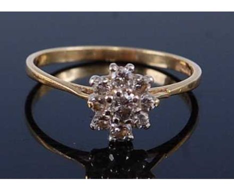 An 18ct gold diamond flower head cluster ring, arranged as a centre claw set round cut in a surround of eight further round c
