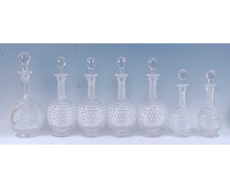 * A set of six 19th century graduated lead glass decanters, the facet cut ball stoppers above a hexagonal cut neck, the Pruss