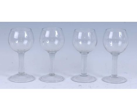 * A matched set of four circa 1740 *style* wine glasses, the cup bowls above a plain straight stem and standing upon a slight