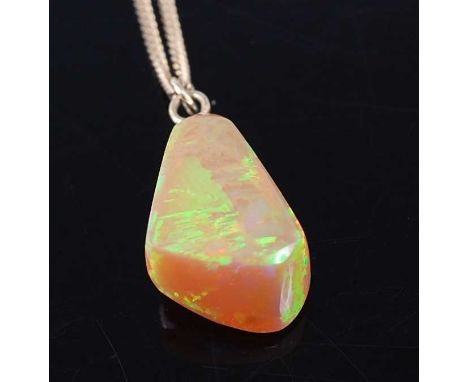 A polished opal pendant, of irregular slab-sided form, estimated weight approx 14 carats, 22mm, on 14ct gold fine curblink ne