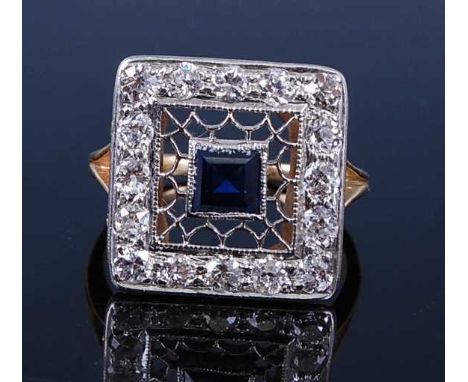 A yellow and white metal, synthetic sapphire and diamond rectangular cluster ring, having a synthetic square cut sapphire wit
