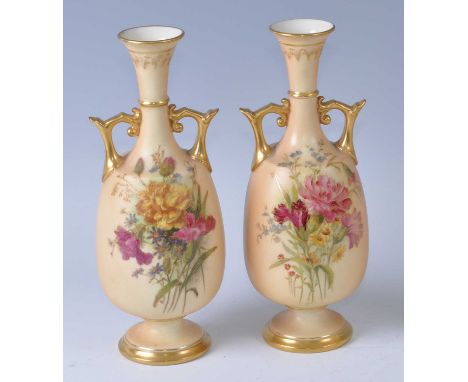 A near-pair of early 20th century Royal Worcester blush ivory porcelain vases, each floral decorated and having angular gilde