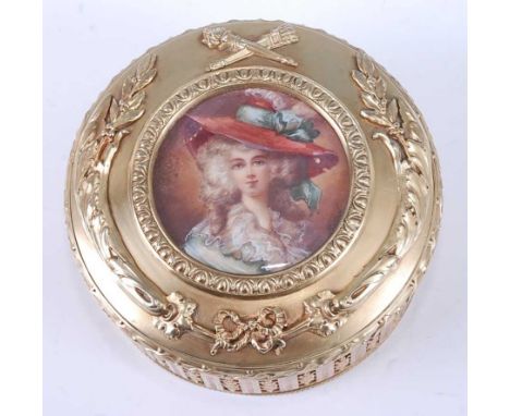 A mid-19th century French gilt metal dressing table box and cover, of cylindrical form and cast with leaves, flowers, ribbons