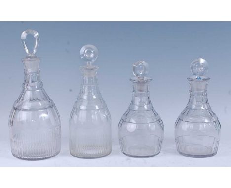 * A matched set of four graduated late Georgian lead glass decanters, the lozenge stoppers above a triple ring neck, flat cut