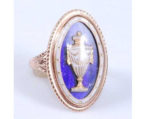 A late Georgian yellow metal memorial ring, of navette form, with blue and white enamel detail depicting an urn, engraved to 