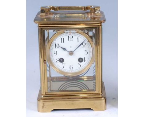 A circa 1900 lacquered brass four-glass oversize carriage clock, having an unsigned white enamel dial, twin winding holes for