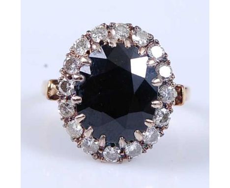 A yellow and white metal, sapphire and diamond oval cluster ring, comprising a centre oval faceted sapphire within a border o
