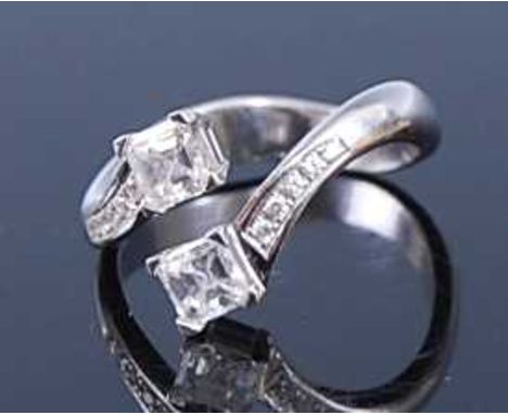 An 18ct white gold diamond crossover ring, arranged as two four claw set Asscher cut diamonds, each weighing approx 0.33 cara