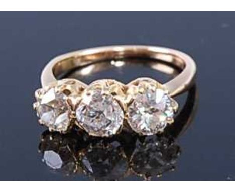 A yellow metal diamond three stone ring, featuring three Old European cut diamonds in claw settings, diamond dimensions betwe