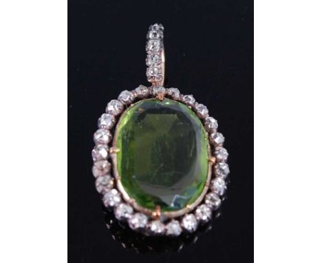 A late 19th century yellow and white metal, peridot and diamond oval cluster pendant, featuring a centre oval faceted peridot