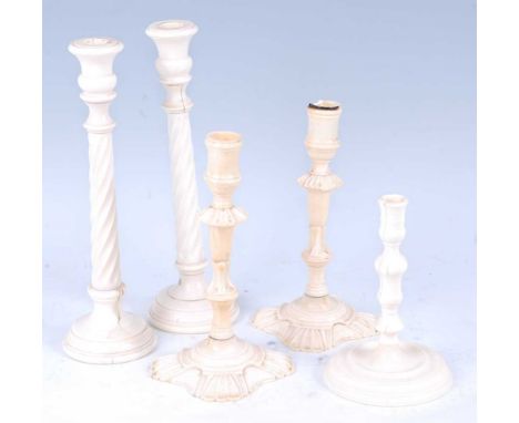 * A pair of 19th century turned ivory candlesticks, each having a bowl shaped sconce on a spirally turned column to domed foo