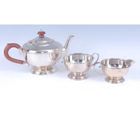 A George V silver three-piece tea set, comprising teapot, twin handled sugar and cream, the teapot with bakelite finial and h