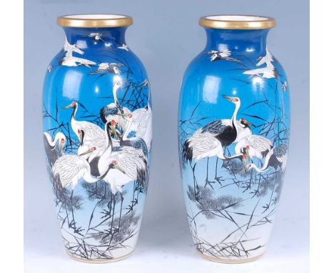 A pair of Japanese satsuma vases, each of slender baluster form, decorated with cranes on a blue ground, signed verso, late M