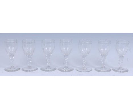 * A set of seven circa 1790 wine glasses, the ovoid bowls engraved with a band of beads and stars below the rim, above a face