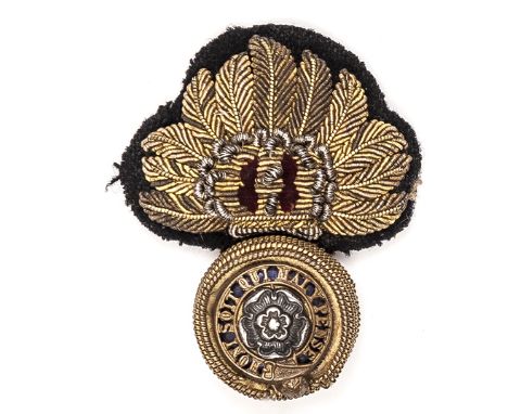 A Vic officer’s embroidered forage cap badge of The Royal Fusiliers, blue enamel backing to gilt (rubbed) and silver plated c
