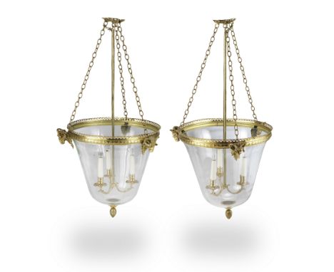 A pair of gilt brass three light hall lanternsWith glass bell domes surmounted by pierced galleries mounted with three ram's 
