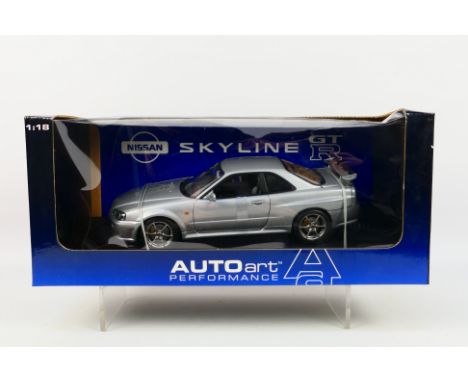 AutoArt - A boxed AutoArt #727631 1:18 scale Nissan Skyline GTR. The model in silver appears to be in Mint condition. The win