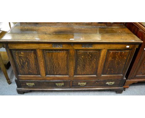 A George III joined oak mule chest, circa 1800, the hinged lid above four fielded panels, two frieze drawers to the base with