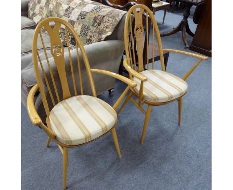 A pair of Ercol armchairs with swan carved splat, labels to underside 