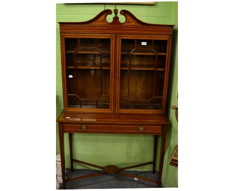 An Edwardian Sheraton style mahogany display cabinet, the broken swan-neck pediment with central urn finial above twin astrag