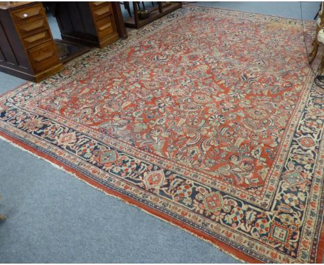 A Mahal carpet, West Iran, the tomato field with an allover design of vines enclosed by indigo borders, 420cm by 312cm (a.f.)